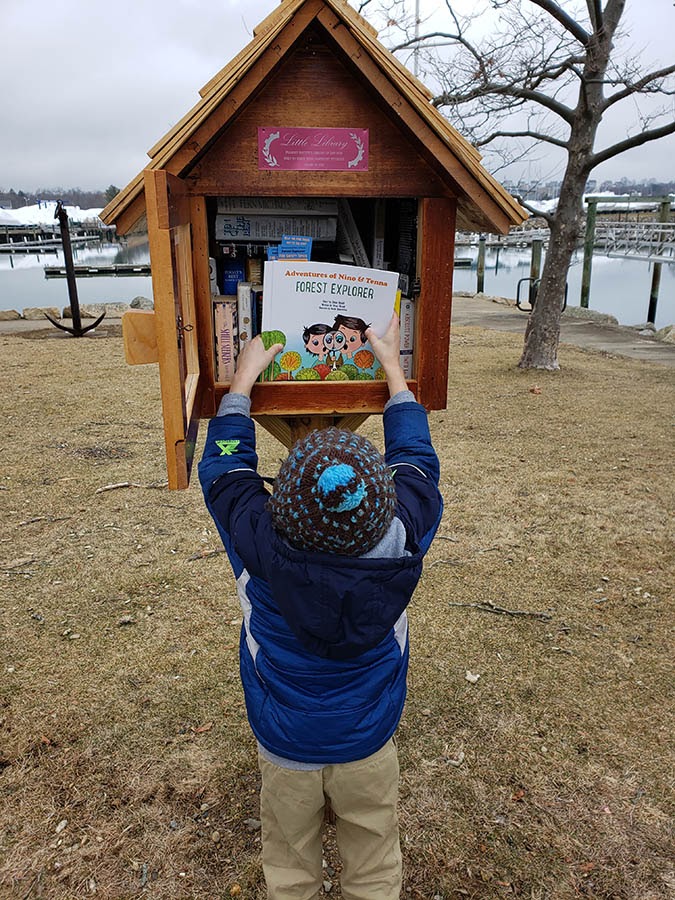 Ethan and his son dropping some copies of a story into the Little Library boxes around town